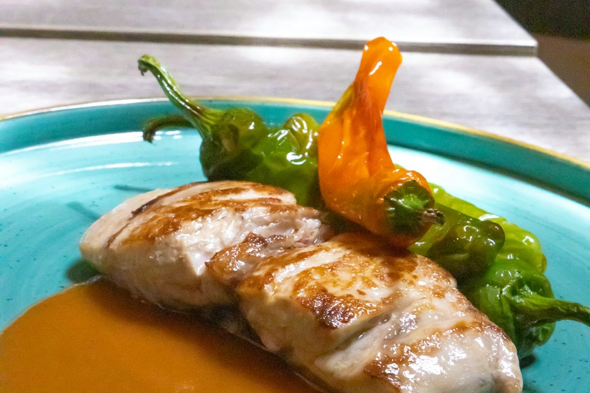 Filete de pescado blanco a la plancha con pimientos rojos, presentación mediterránea